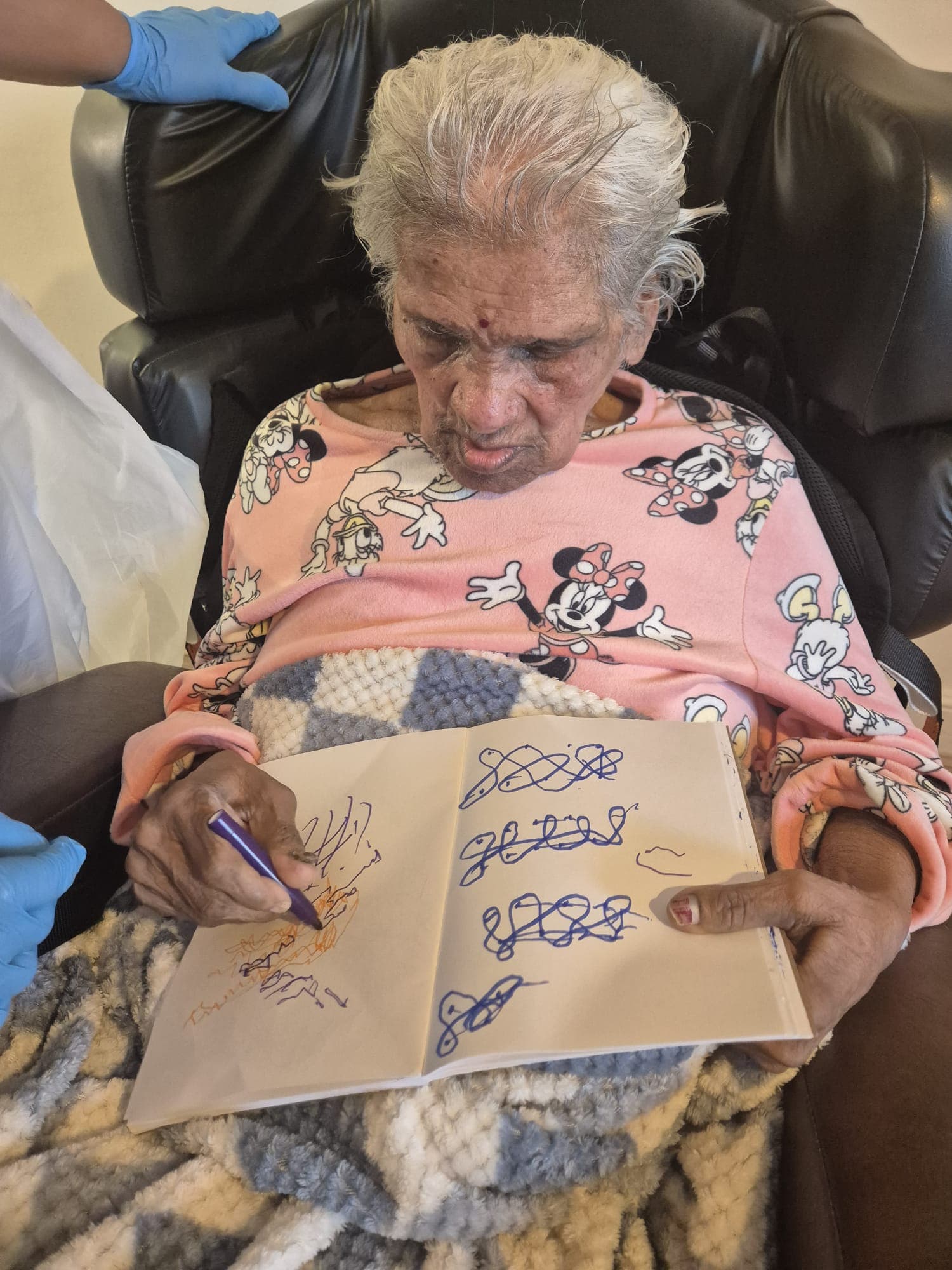 Resident proudly displaying artwork completed during a visit